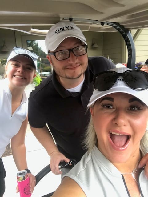 Associates having fun at the company golf outing — a candid selfie between holes